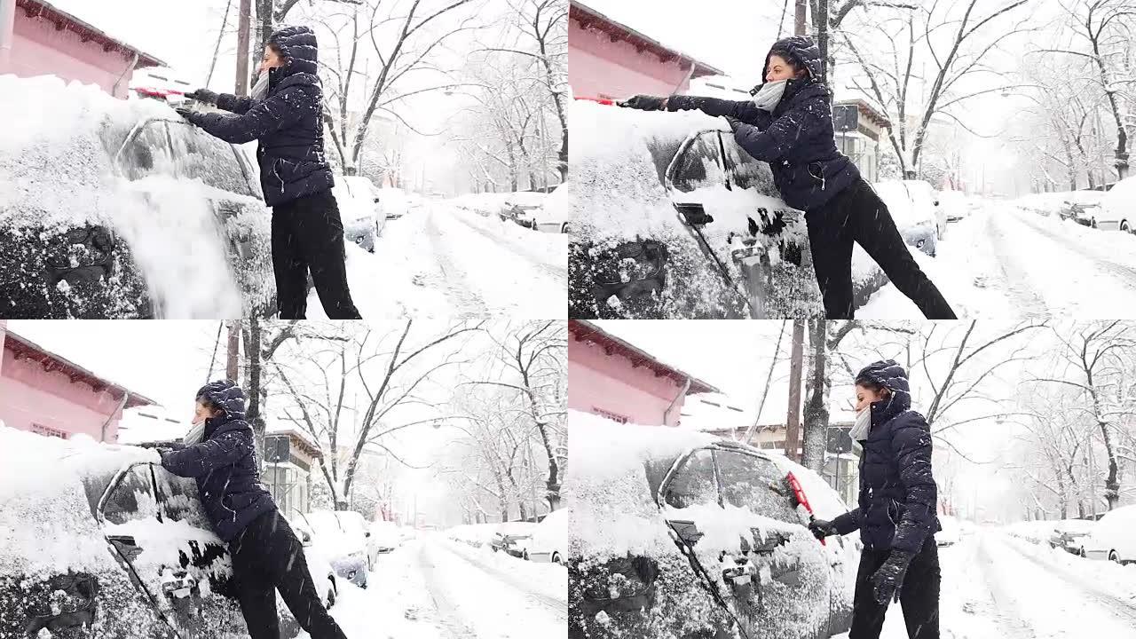 年轻女子清理汽车上的积雪。