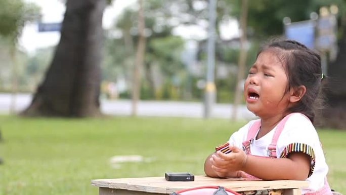 亚洲女孩在公园里哭泣。