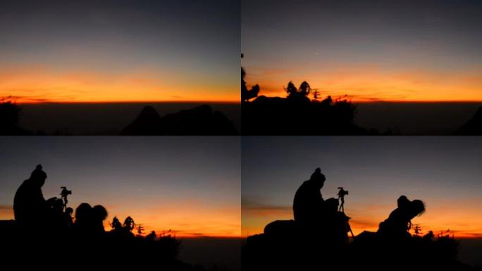 摇摄：黄昏时两名游客在山顶