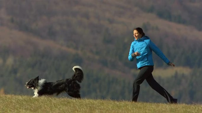 高清超级慢动作: 年轻女子和她的狗一起跑步
