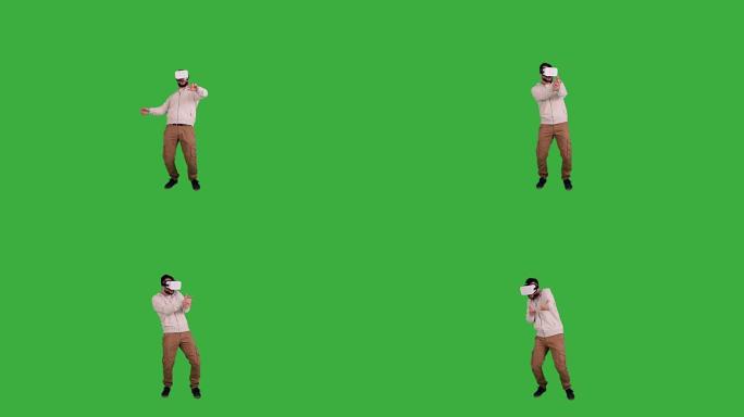 戴眼镜的快乐男人虚拟现实在绿色背景上玩耍