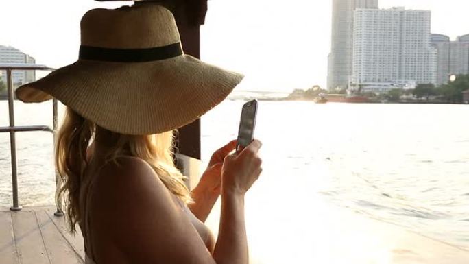 一名女子从河上的船上拍摄了湄南河这座城市的照片