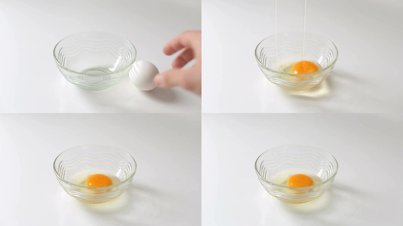 手在白底碗里敲碎鸡蛋