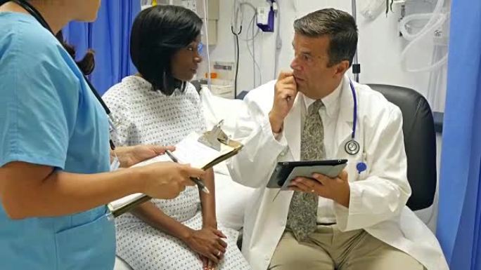 成熟的高加索医生在急诊室与年轻的非洲裔美国患者交谈
