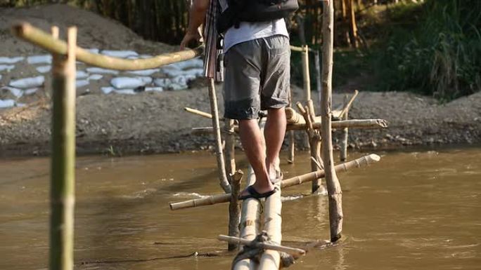 男人在竹桥上过河