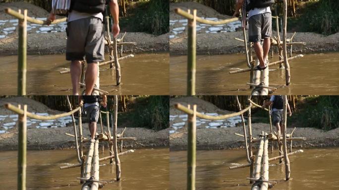 男人在竹桥上过河