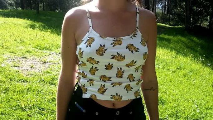 穿着香蕉T恤在公园里散步的女孩