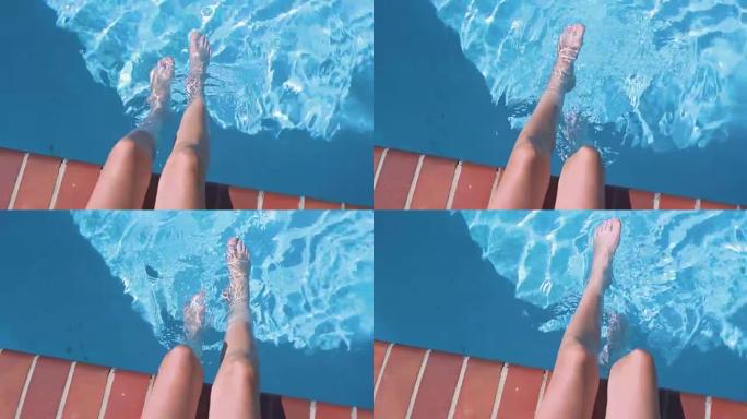 少年女孩的腿在后院游泳池的水中