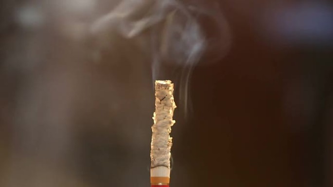 香烟在孤立背景的空气中燃烧。
