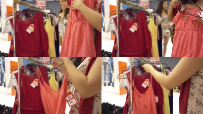 女人在服装店购物挑选选择夏季吊带装开放式