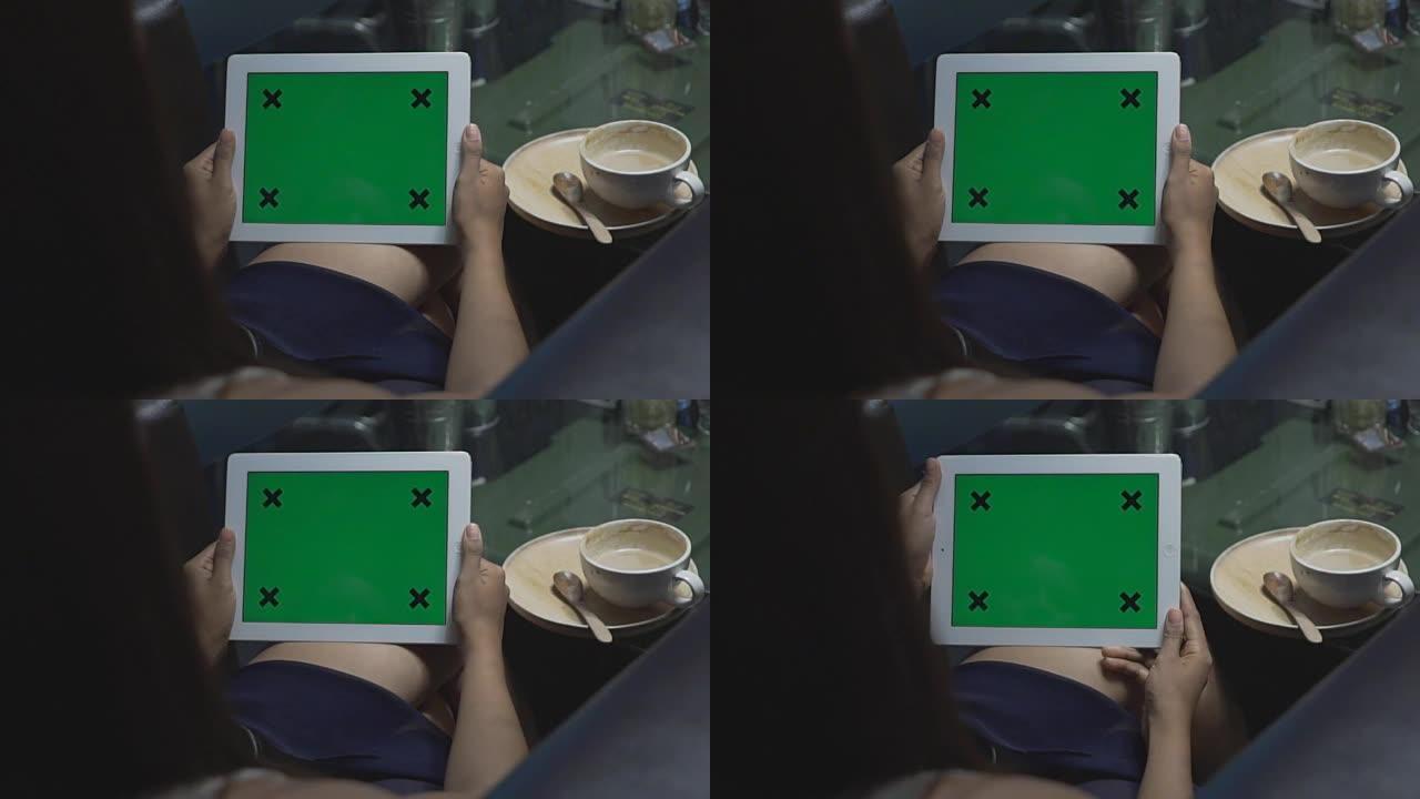 特写女性手持空白平板电脑，绿色