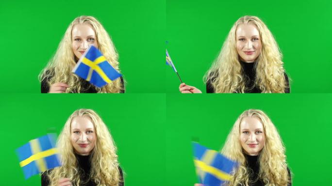 一名年轻女子在绿幕背景下挥舞着瑞典国旗
