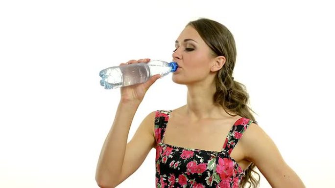 年轻漂亮的女人在白底上喝水。