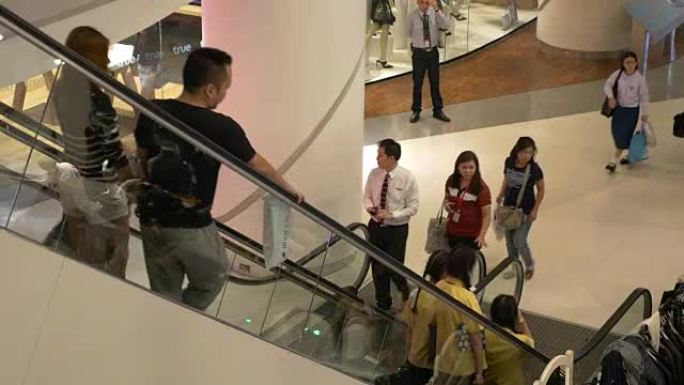 人们在购物中心内的自动扶梯楼梯上移动