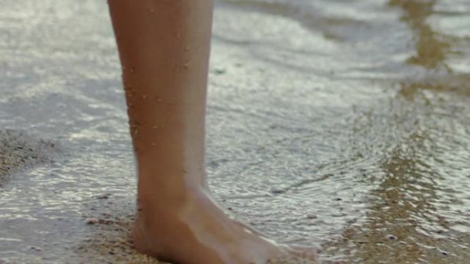 小女孩的脚在热带海滩上行走