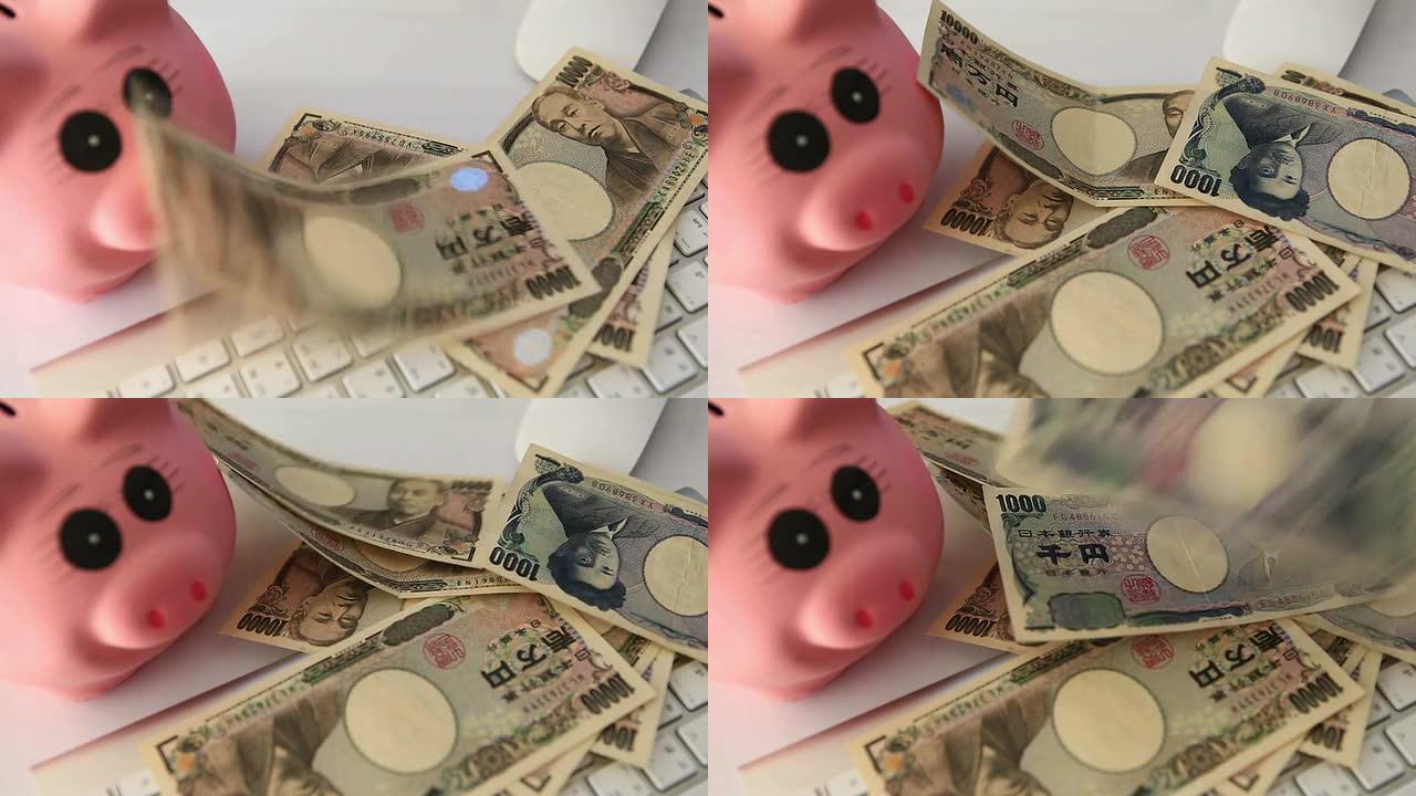 落在日元的键盘上纸币小猪金钱