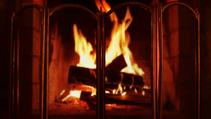 壁炉里烧木头。壁炉防护罩。