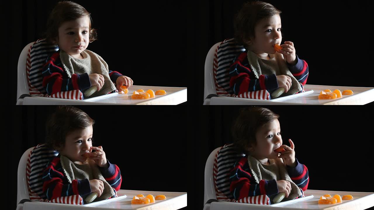 男婴坐在高脚椅上吃水果