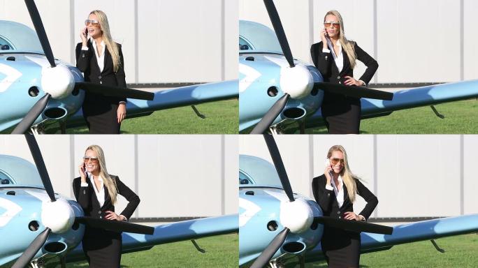 站在一架小型飞机旁边的女商人