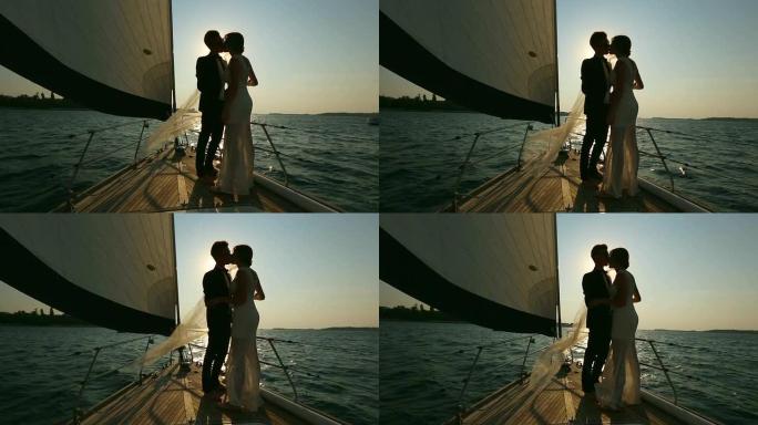 新娘和新郎在游艇上接吻的剪影