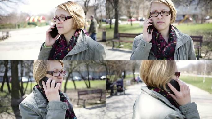 年轻的母亲在公园里使用手机