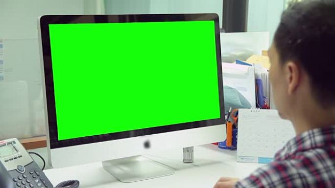 高清: 使用显示器绿屏工作的人 [向上倾斜]