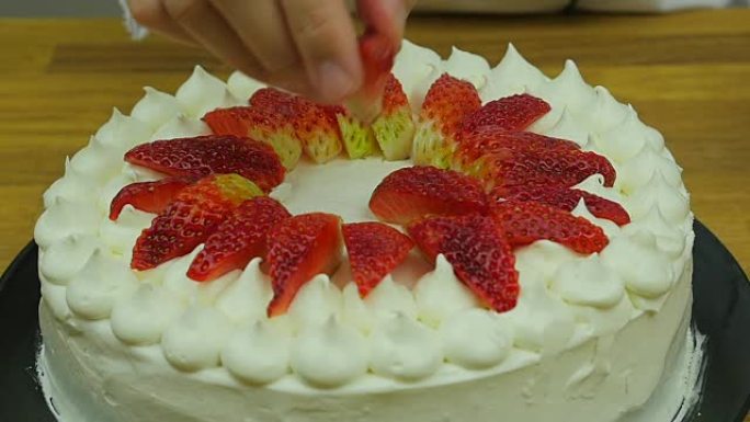 厨师用草莓慢动作装饰蛋糕