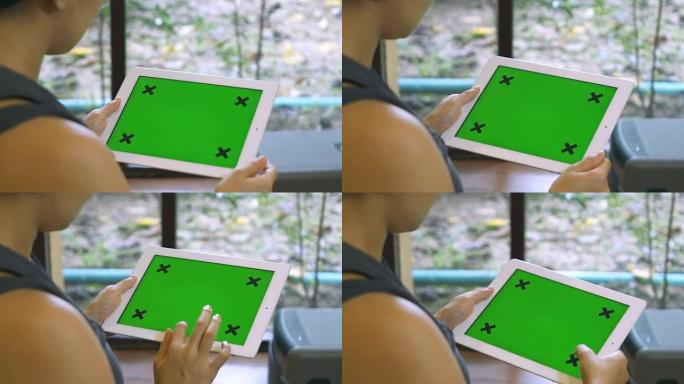 特写女性手持空白平板电脑，绿色