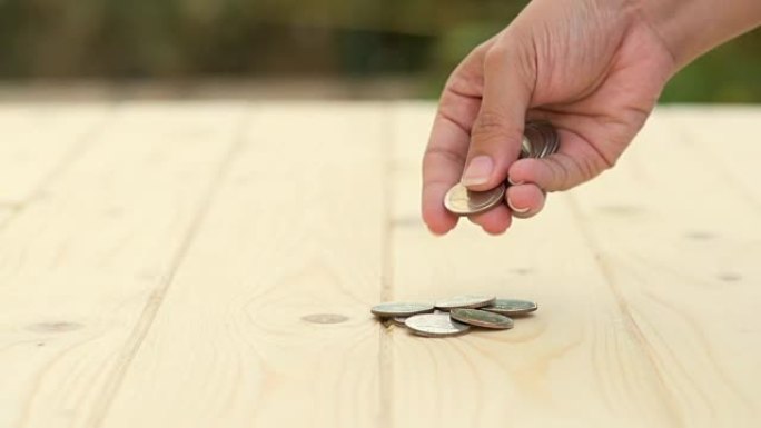 高清: 手工计算木桌上的硬币