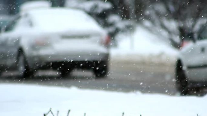 雪暴冬季交通。汽车在湿滑的路上行驶。雪花飘落。