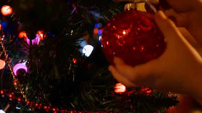男孩在新年的圣诞树上挂了一个球