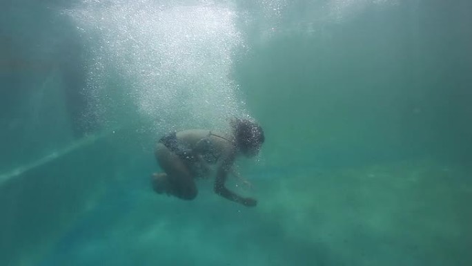 年轻女子跳入水中下潜