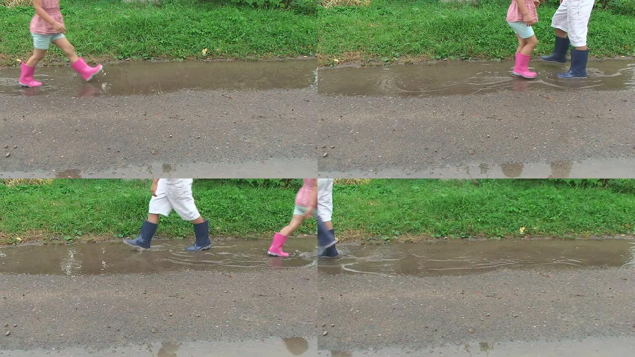 穿着五颜六色雨靴的孩子们踩着泥坑。