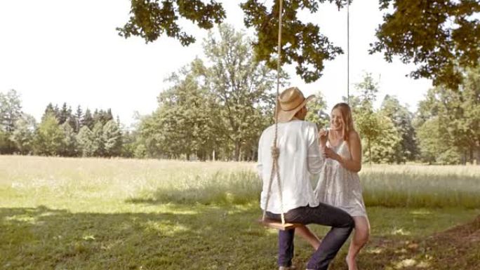 SLO MO夫妇在秋千上吹泡泡