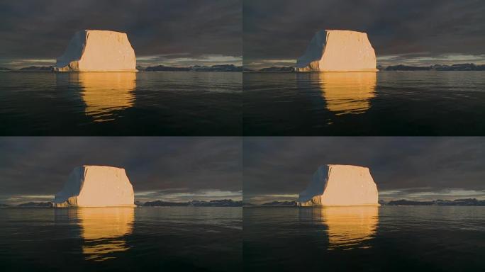 巨大的冰山漂浮在格陵兰岛的午夜阳光下