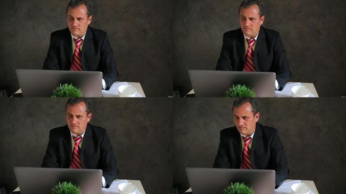 成熟的商人在笔记本电脑上工作