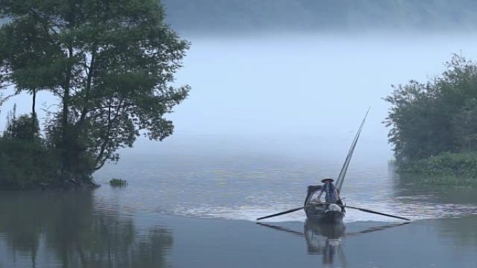 雾天宁静湖水上的小渔船