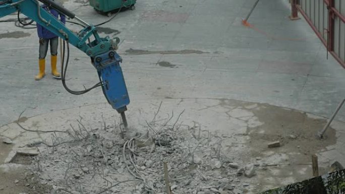 工人在街上用压缩机钻混凝土