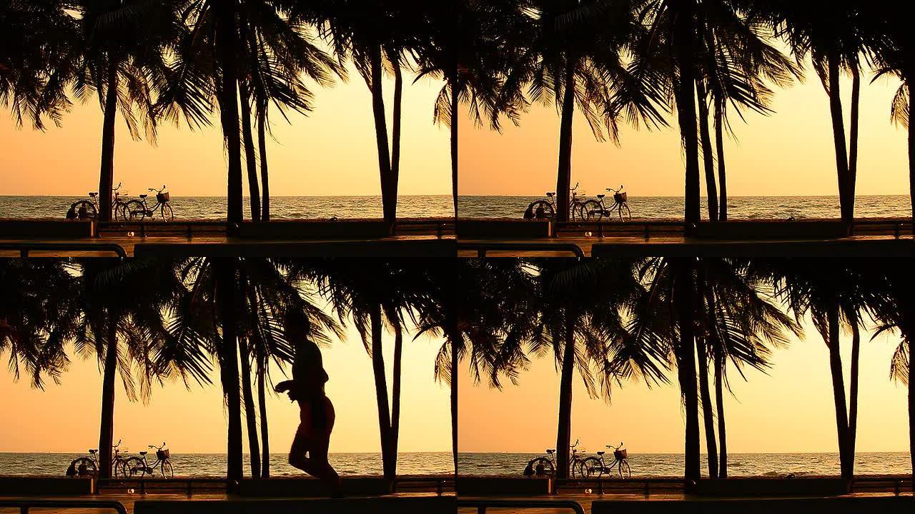 两个女孩骑着自行车在日落的棕榈树海滩放松