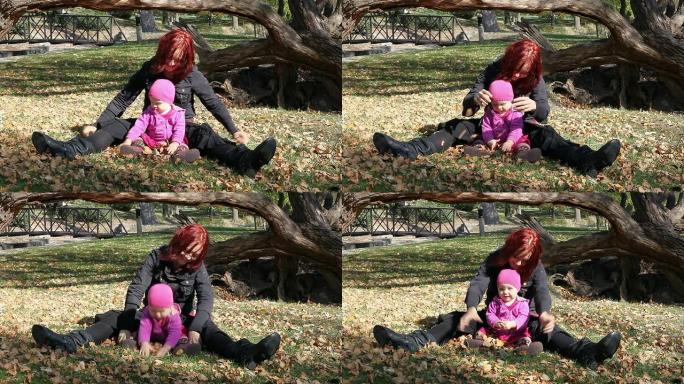 妈妈和宝贝女儿玩树叶