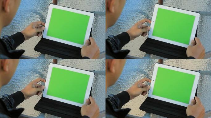 特写男子手持空白平板电脑，绿色
