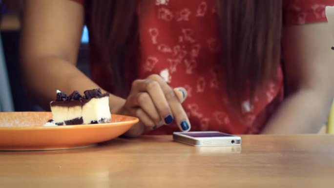 亚洲女孩在餐厅使用智能手机