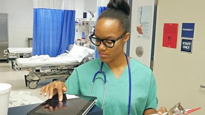 年轻的非洲裔美国护士正在使用数字平板电脑为她的下一个病人做准备