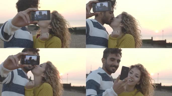 情侣在海滩上用手机摄像头自拍