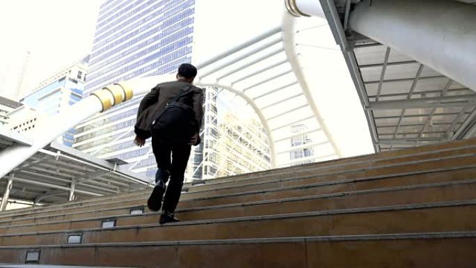 商人冲上楼梯在现代城市工作的慢动作镜头