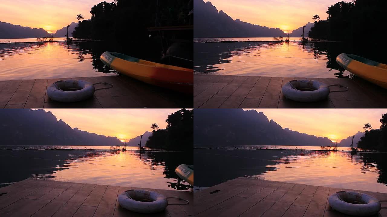 日落时分的码头，配有独木舟和救生圈