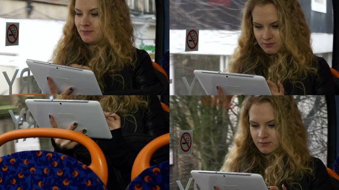 年轻女子在公交车上拿着数字平板电脑