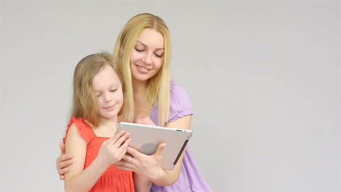 母亲和女儿在数字平板电脑上交谈