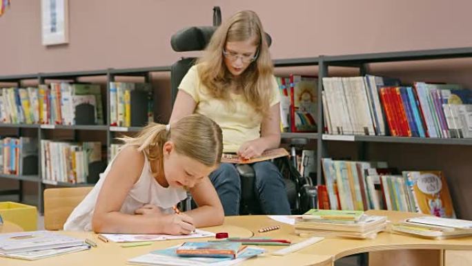 坐在轮椅上的DS女人向图书馆的一个小女孩递蜡笔