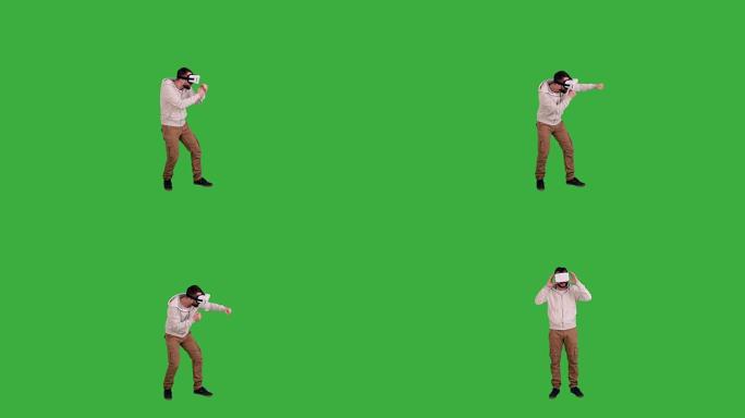 戴眼镜的快乐男人绿色背景上的虚拟现实拳击